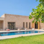 Vue de la piscine et de la façade de la Villa Jnan Mogador depuis le jardin.