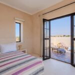 Chambre double de la Villa Jnan Mogador avec portes vitrées ouvertes sur la terrasse.