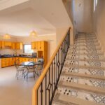 Cuisine ouverte avec espace repas, à côté de l’escalier carrelé de la Villa Jnan Mogador.