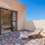 Terrasse carrelée de la Villa Jnan Mogador avec transat et accès à la chambre à l’étage.